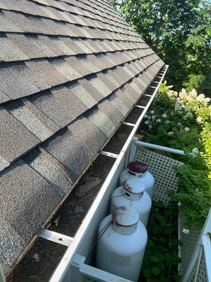 Gouttière bouchée par un amas de feuilles avant débouchage à Brossard